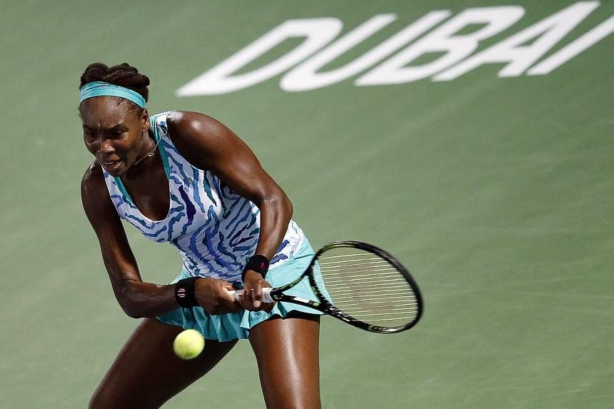 Venus Williams of the USA returns the ball to Belinda Bencic of Switzerland during their second round of the Dubai Duty Free Tennis WTA Championships in the United Arab Emirates on Monday. -- PHOTO: EPA