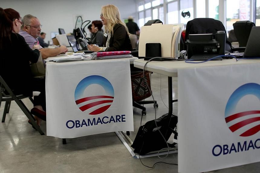 Aymara Marchante (left) and Wiktor Garcia sit with Maria Elena Santa Coloma, an insurance advisor with UniVista Insurance company, as they sign up for the Affordable Care Act, also known as Obamacare, before the February 15th deadline on Feb 5, 2015 