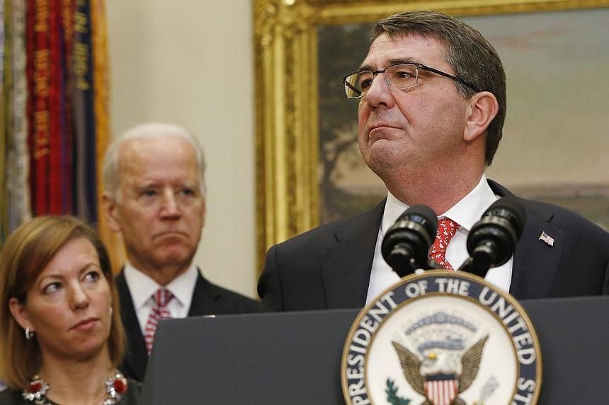 New US Secretary of Defense Ash Carter (right) delivers his acceptance speech at the White House in Washington on Feb 17, 2015.&nbsp;With him are his wife Stephanie (left) and US Vice-President Joe Biden. -- PHOTO: REUTERS