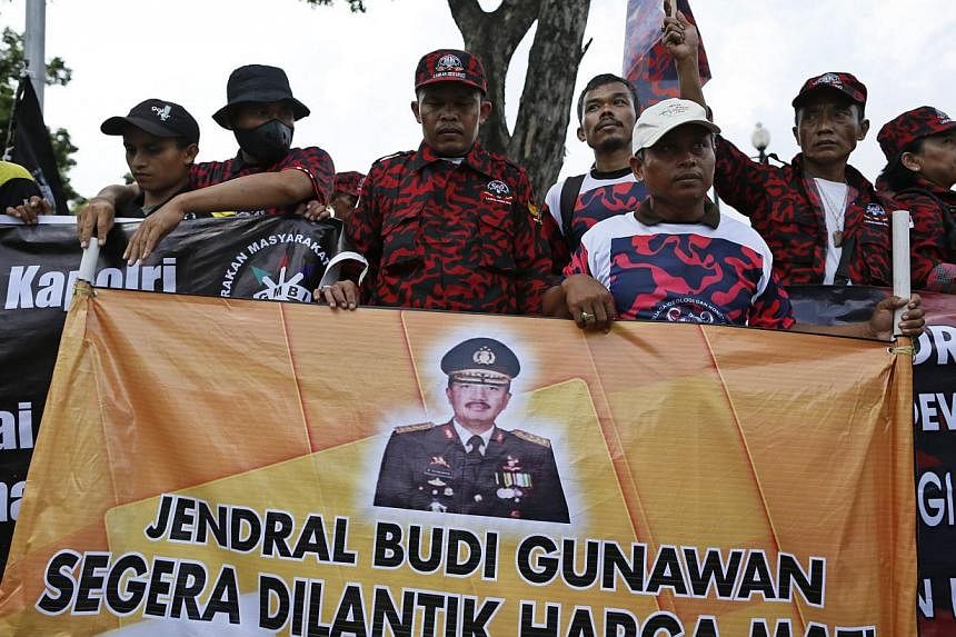 Supporters of Indonesian police chief nominee Budi Gunawan holding a banner with his picture outside the presidential palace in Jakarta, Indonesia on Feb 16, 2015,&nbsp;shortly after an Indonesian court cleared the three star general of being a graft