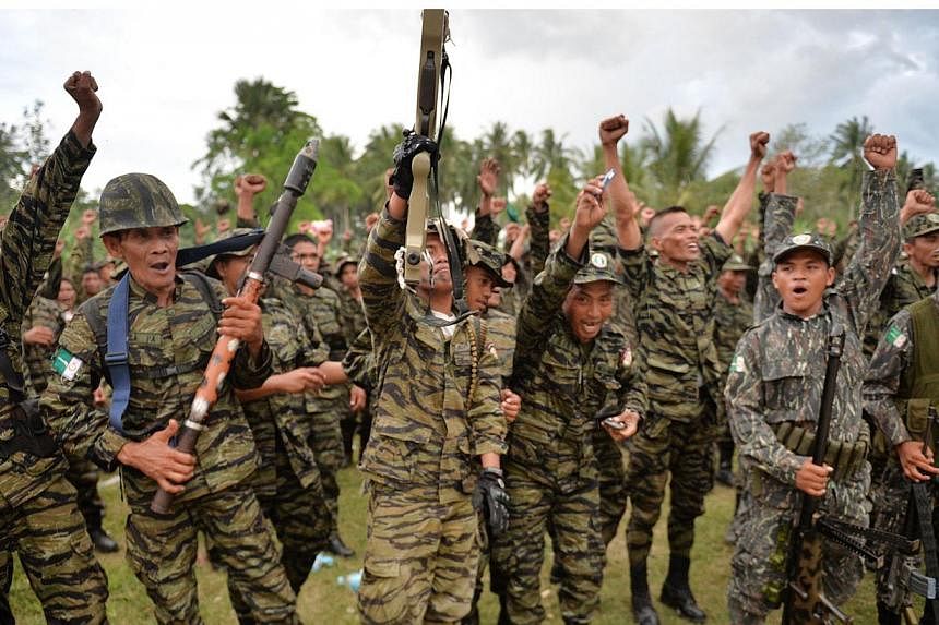 This file photo taken on March 27, 2014 shows Moro Islamic Liberation Front (MILF) rebels shouting as they celebrate the signing of a peace agreement during a rally at Camp Darapanan in the town of Sultan Kudarat on the southern Philippine island of 