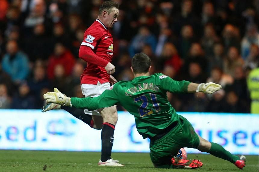 Preston's Thorsten Stuckmann (right) concedes a penalty against Manchester United's Wayne Rooney. -- PHOTO: REUTERS