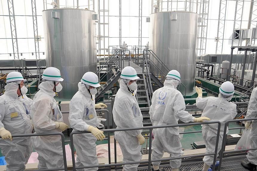 This handout picture released by International Atomic Energy Agency (IAEA) on Feb 17, 2015, shows IAEA mission team members inspecting TEPCO's Fukushima Daiichi Nuclear Power Station in Okuma, Fukushima prefecture.&nbsp;International advisers to Japa