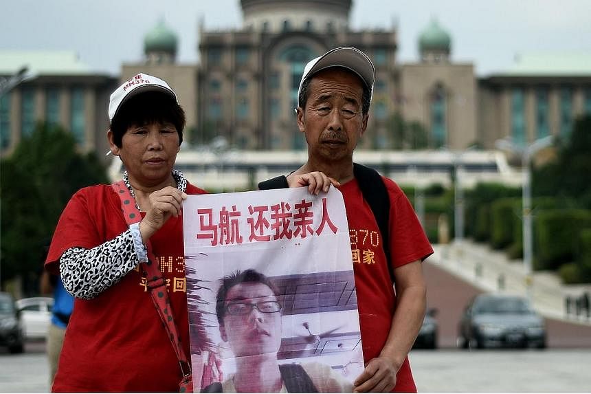 Relatives of Chinese passengers from the missing Malaysia Airlines flight MH370 gather outside Malaysian Prime Minister Najib Razak's office in Putrajaya on Feb 18, 2015. -- PHOTO: AFP