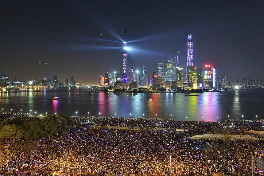 People watch a light show before a stampede incident occurred at the New Year's celebration on the Bund, a waterfront area in central Shanghai Dec 31, 2014. Shanghai is toning down Chinese New Year celebrations by cancelling events and limiting peopl