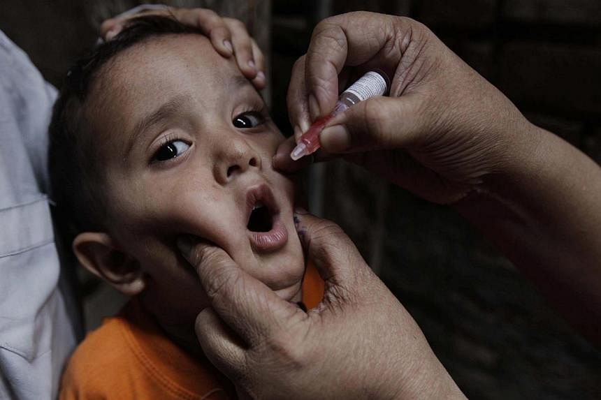 A health worker administers a polio vaccine to a child, in Peshawar, Pakistan, on Feb 17, 2015. Four members of a polio immunisation team have been found murdered after being kidnapped in south-west Pakistan, officials said Wednesday.&nbsp;-- PHOTO: 