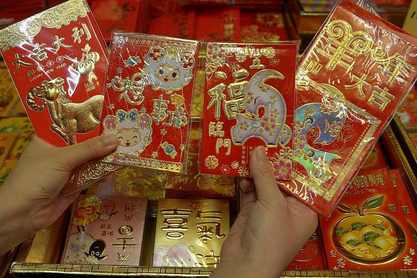 The Chinese tradition of giving gifts of money in red envelopes during the Lunar New Year has turned into big business for Web giants Alibaba and Tencent, which now both offer electronic hongbao. -- PHOTO: ST FILE