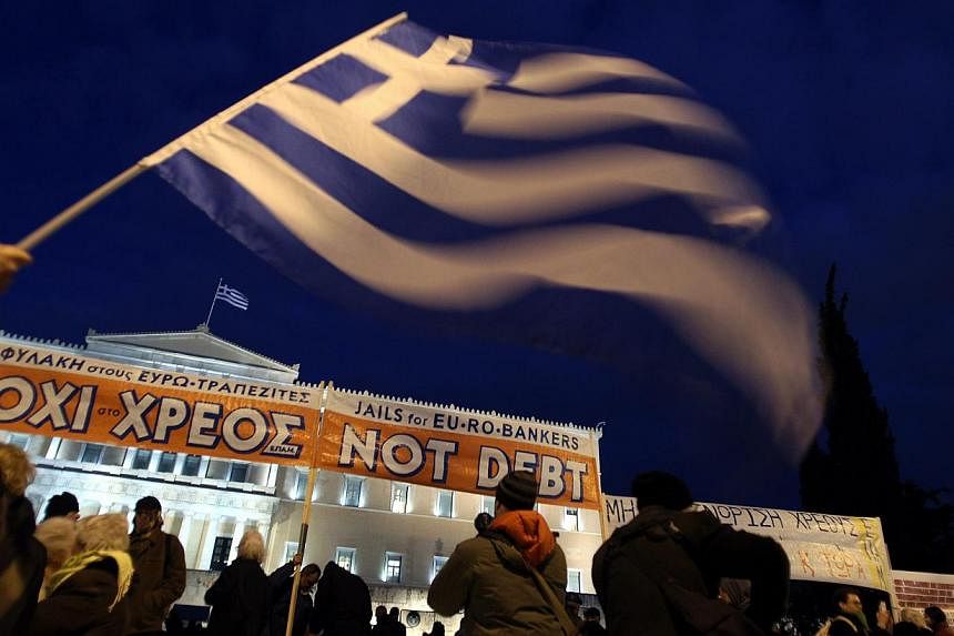 People holding flags and banners gather in front of the parliament building in Athens during a rally in support of the Greek government's negotiations at the Eurogroup meeting in Brussels, on Feb 16, 2015. -- PHOTO: EPA