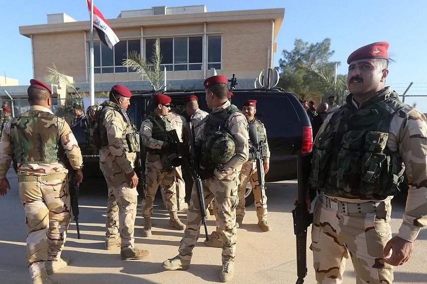 Iraqi army soldiers standing before a conference on fighting ISIS in November attended by Iraq's tribal leaders, militiamen and members of the government, at the Al-Asad air base, in Iraq's mainly Sunni Anbar province. Iraqi soldiers backed by US-led
