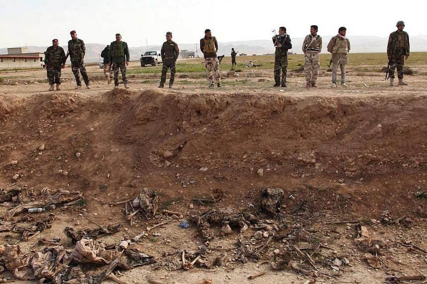 Kurdish peshmerga forces look at bones in a mass grave on the outskirts of the town of Sinjar Iin Iraq on February 3. Police said the mass grave contained remains from 25 people belonging to the minority Yazidi sect, apparent victims of killings by I