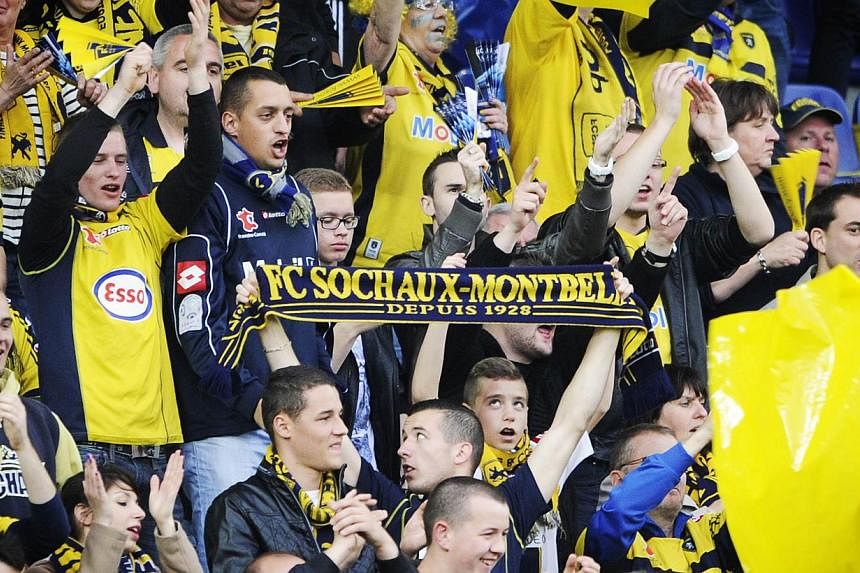 Sochaux-Montbeliard 's football team supporters holding a scarf reading "FC Sochaux Montbeliard, since 1928" during a football match between Sochaux and Evian at the Auguste Bonal stadium in Montbeliard last year.&nbsp;-- PHOTO: AFP