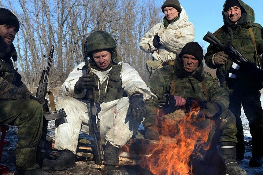 Pro-Russian rebels warm themselves by a fire during a break between fighting near the eastern Ukrainian city of Debaltseve on Feb 17, 2015. -- PHOTO: AFP