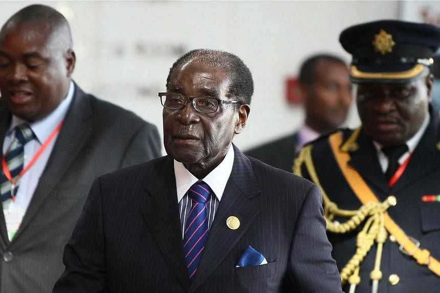 Zimbabwe's President Robert Mugabe (centre) arrives for the 24th Ordinary session of the Assembly of Heads of State and Government of the African Union (AU) at the African Union headquarters in Ethiopia's capital Addis Ababa, on Jan 31, 2015. -- PHOT