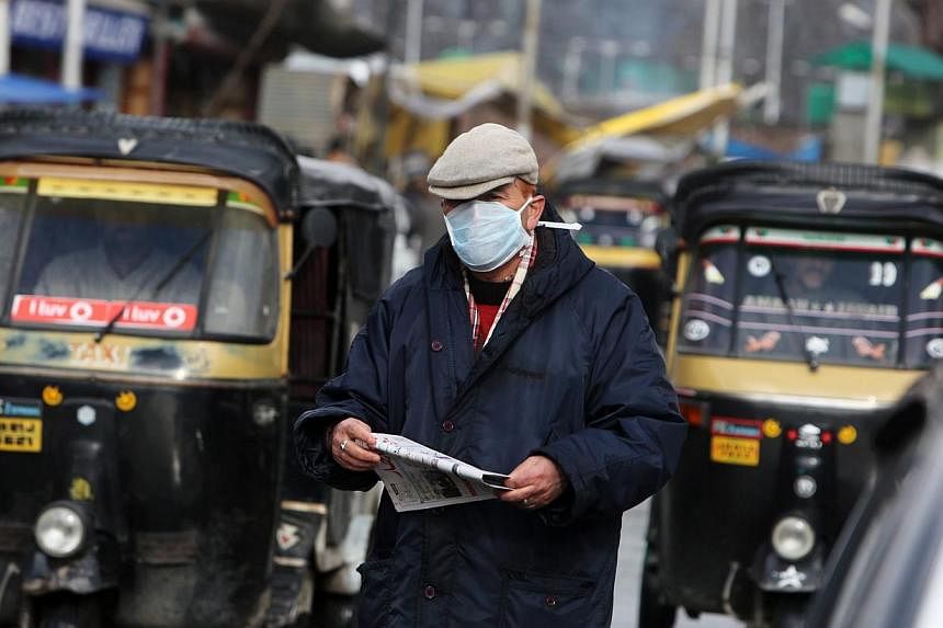 A Kashmiri man wearing a mask walks on a busy street in Srinagar, the summer capital of Indian Kashmir on Feb 18, 2015. India is urging its states to ensure sufficient supply of anti-flu medication and diagnostic tests as it struggles to curb an outb