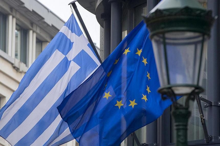 A Greek (left) and a European flag flutter outside the Greek embassy in Brussels on Feb 19, 2015.&nbsp;Greece has made every effort to reach a mutually beneficial agreement with its euro zone partners but will not be pushed to implement its old bailo