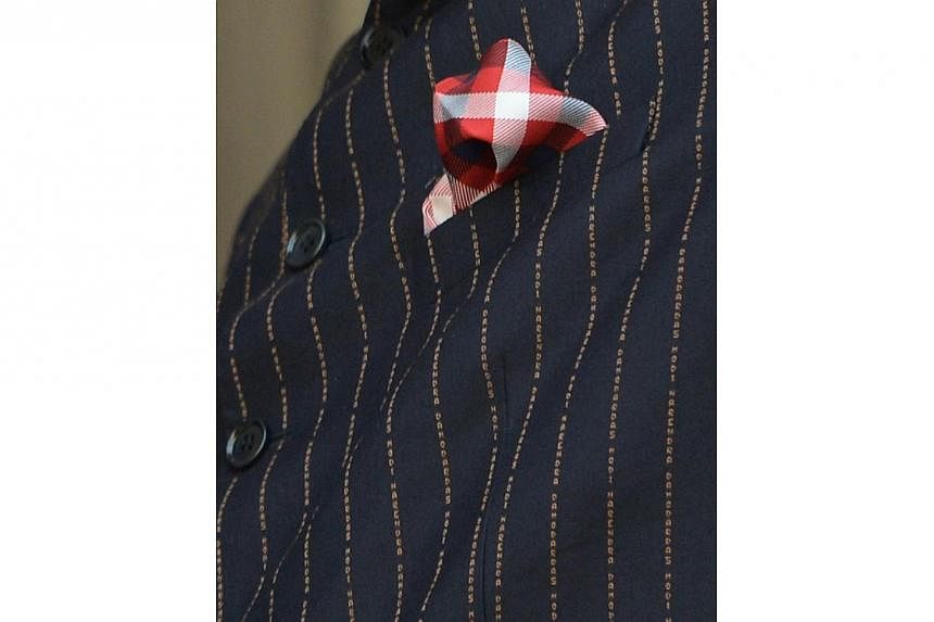 This photograph taken on Jan 25, 2015, shows detailS on Indian Prime Minister Narendra Modi's suit bearing his own name during a joint press conference after delegation level talks with US President Barack Obama in New Delhi. -- PHOTO: AFP