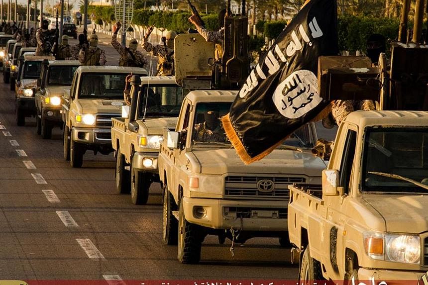 An image made available by propaganda Islamist media outlet Welayat Tarablos on Feb 18, 2015, allegedly shows ISIS militants parading in a street in Libya's coastal city of Sirte, which lies some 500km east of the capital, Tripoli. -- PHOTO: AFP