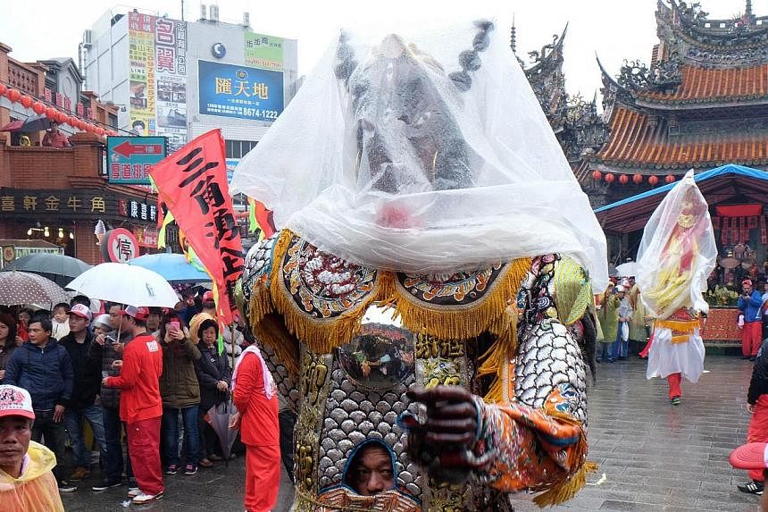 A man dressed in a Taoist god costume attending the annual "Holy Pigs" Festival outside the Zushi Temple in Shanhsia district, New Taipei City on Feb 24, 2015. -- PHOTO: AFP