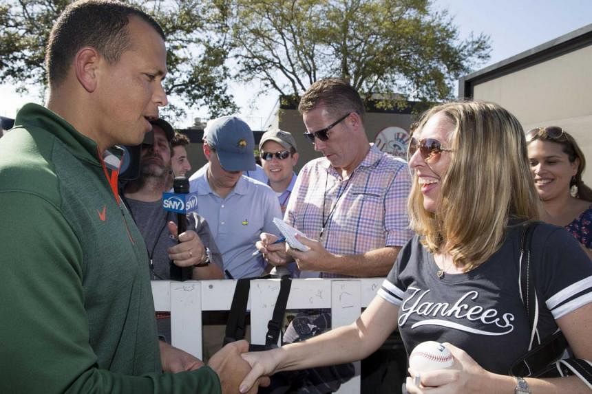New York Yankees' Alex Rodriguez (L) greets a fan waiting for a autograph at the Yankees minor league complex for spring training in Tampa, Florida on Feb 23, 2015. -- PHOTO: REUTERS