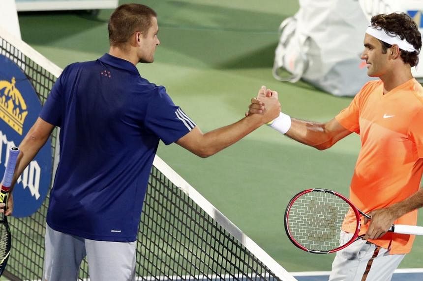 Mikhail Youzhny of Russia (L) shakes hand with Roger Federer of Switzerland at the end of their match at the ATP Championships tennis tournament in Dubai, Feb 23, 2015. -- PHOTO: REUTERS
