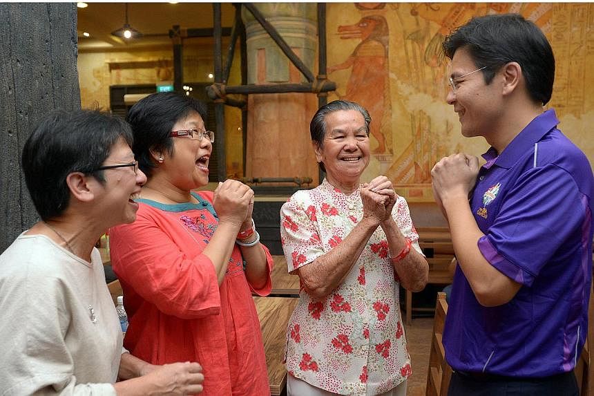 Minister for Community, Culture and Youth Lawrence Wong greeting three volunteers of the 28th SEA Games to be held in Singapore, from second right, Mdm Seah Wai Ying, 84, Ms Choo Bee Leng, 51 and Mdm Seah's daughter, Ms Lim Lea Cheen, 53. -- ST PHOTO