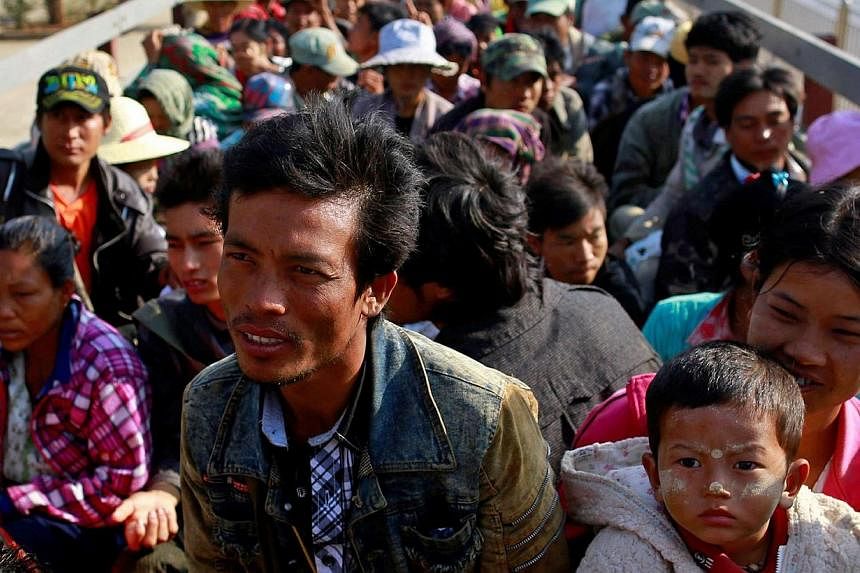 Migrant workers who fled from Karmine ride a vehicle to return home, after staying at a temporary refugee camp in Lashio Feb 21, 2015. Fighting broke out on Feb 9 between the army and a rebel force in the Kokang region of northeast Myanmar, on the bo