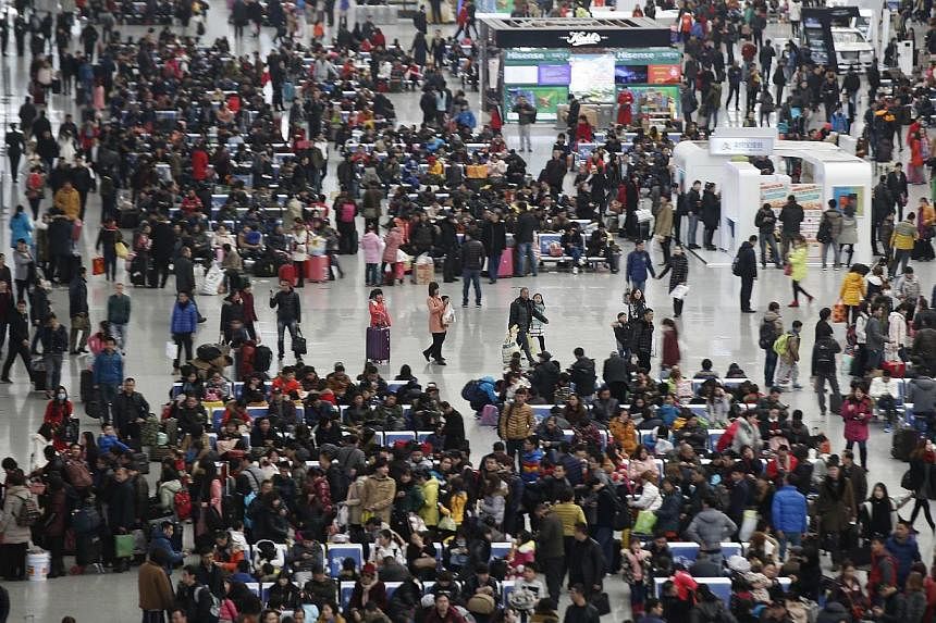 People wait in line to board their trains at Hongqiao train station in Shanghai, ahead of Chinese New Year on Feb 9, 2015. Vast numbers of Chinese were heading back to their workplaces Tuesday as the Chinese New Year holiday drew to a close. -- PHOTO