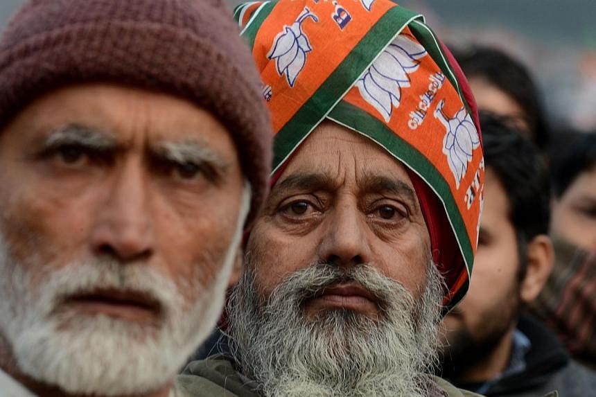 Kashmiri supporters of Indian Prime Minister Narendra Modi look on as he speaks during an election rally at a stadium in Srinagar on Dec 8, 2014. Prime Minister Narendra Modi hit the campaign trail for regional elections in Indian Kashmir just days a