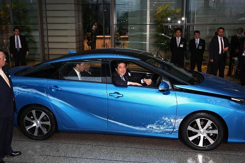 Japan's Prime Minister Shinzo Abe taking Japanese automaker Toyota's first commercial fuel cell vehicle for a ceremonial test drive at the prime minister's office in Tokyo on Jan 15, 2015. -- PHOTO: AFP