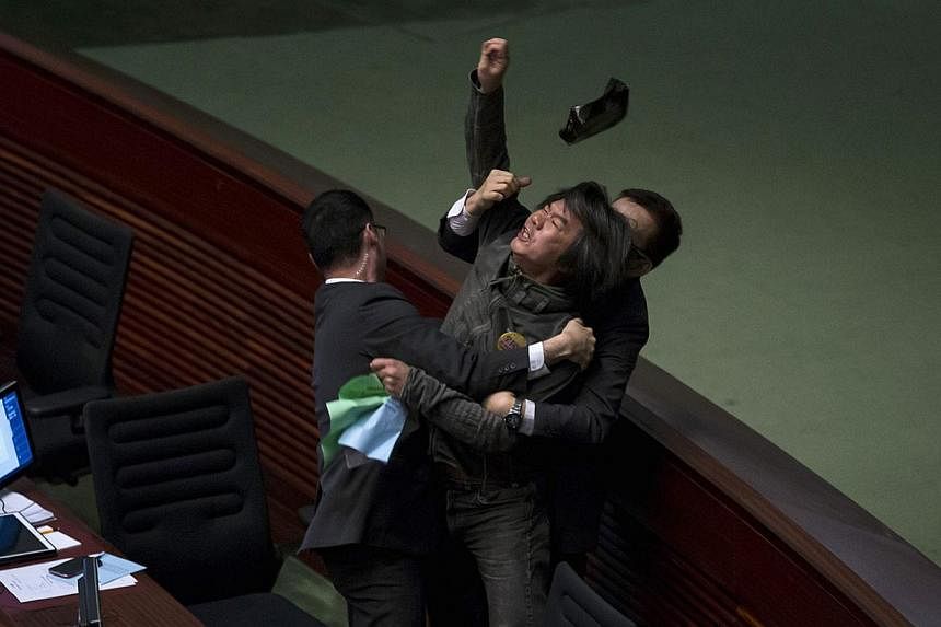 Pro-democracy lawmaker Leung Kwok-hung throws an object at Hong Kong's Financial Secretary John Tsang (not pictured) to demand a universal retirement protection scheme during the annual budget report at the Legislative Council in Hong Kong Feb 25, 20
