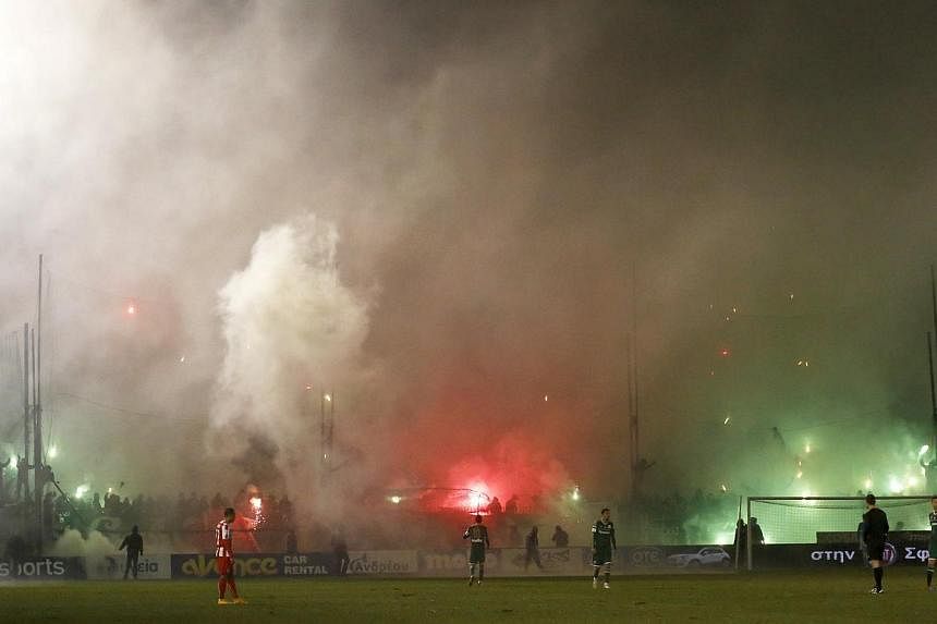 Smoke from flares lit by Panathinaikos' fans rises during the Greek Super League football match between Panathinaikos and Olympiakos at Leoforos stadium in Athens on Feb 22, 2015. -- PHOTO: REUTERS