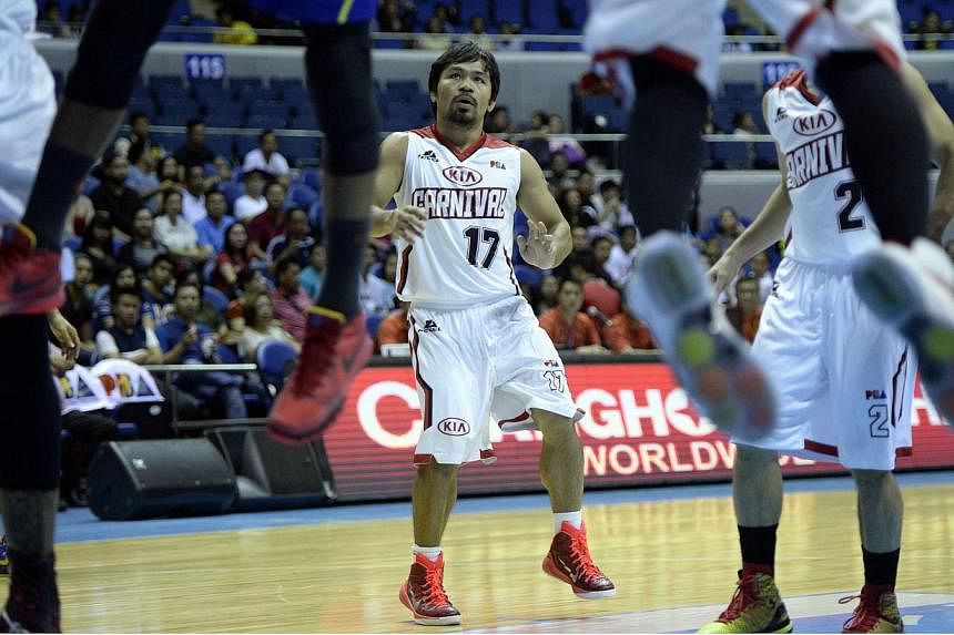 Philippine boxing hero Manny Pacquiao (centre), playing for Kia, looks as players rebound a ball from the basket during a professional basketball game between Kia and Talk and Text in Manila on Feb 25, 2015. Philippine basketball authorities have sac