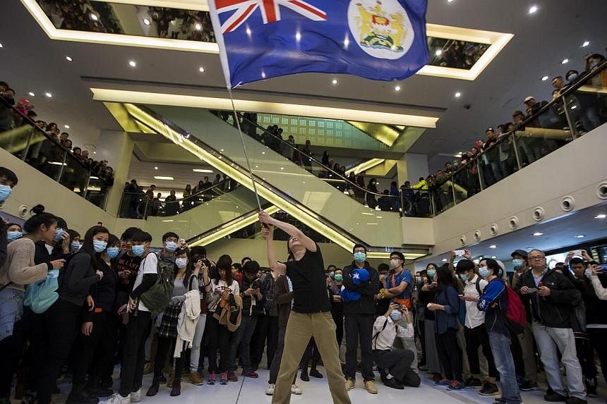 A protester waving a colonial Hong Kong flag during a demonstration inside a shopping mall in Hong Kong on Feb 15, 2015. The city has pledged HK$290 million (S$50.74 million) to help businesses hit by more than two months of pro-democracy protests. -