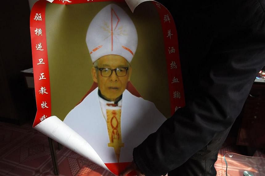 A relative unfurls a photo of Bishop Shi Enxiang at the family home in Shizhuang, in China's northern Hebei province. The family of Chinese underground Catholic bishop Shi Enxiang, who spent more than 50 years in detention for maintaining his loyalty
