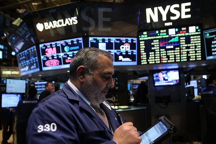 Traders working on the floor of the New York Stock Exchange. The Dow Jones Industrial Average rose 92.35 points, besting Friday’s record by about 70 points, and the broad-based S&amp;P 500 inched up to a new all-time close. -- PHOTO: AFP