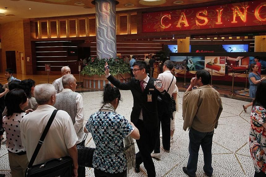 Tourists outside the casino at Resorts World Sentosa. Shares of Genting Singapore slumped to their lowest since May 2010 on Feb 25, 2015, after the casino operator reported a 30 per cent drop in fourth-quarter profit, hurt by poor performance in its 