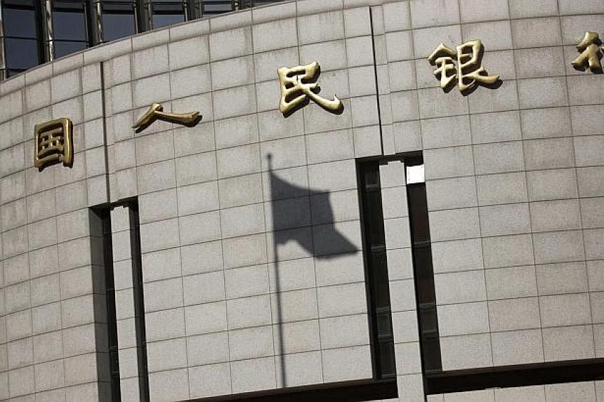 A fluttering Chinese national flag casts its shadow on the headquarters of the People's Bank of China, China's central bank, in central Beijing in this Nov 24, 2014 file photo. China is dangerously close to slipping into deflation, the central bank's