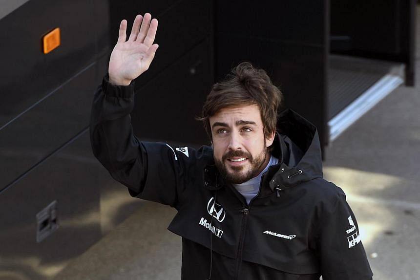 Fernando Alonso waves during the Formula One pre-season second day test at Catalunya's racetrack in Montmelo, near Barcelona, on Feb 20, 2015. Alonso left hospital in Barcelona on Wednesday. -- PHOTO: AFP&nbsp;