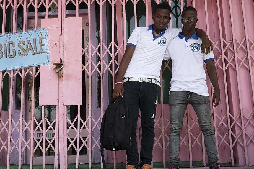Ebola survivors Musa Pabai (left) and his brother Osumba Aride pose for a picture on the sidelines of an Ebola survivors' Valentine's Day Parade in Monrovia Feb 14, 2015. Three months on from his infection, Musa Pabai was too afraid to return to his 