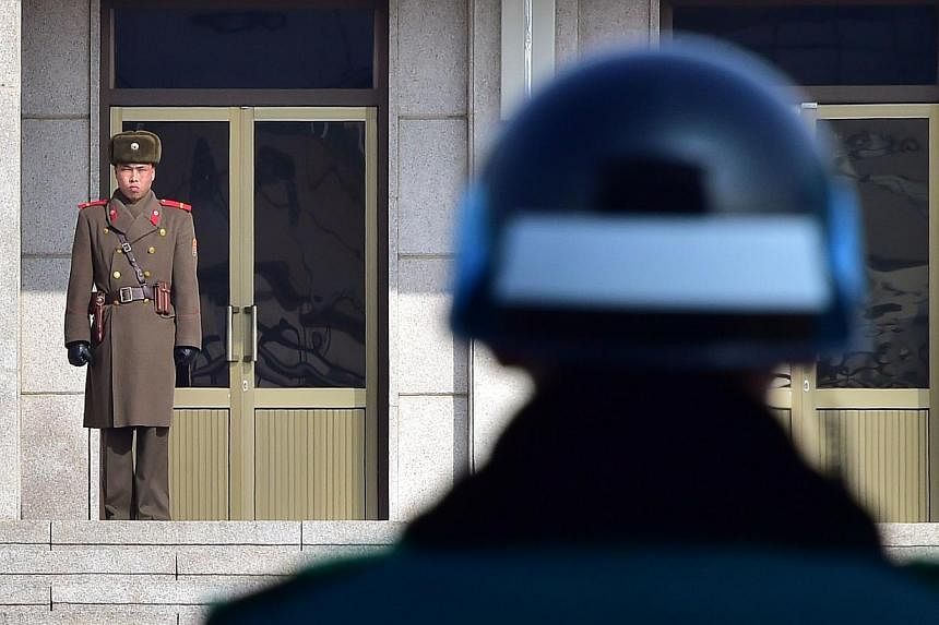 A North Korean soldier (left) and a South Korean soldier (right) stand opposite each other at the truce village of Panmunjom in the Demilitarized Zone dividing the two Koreas on Feb 4, 2015.&nbsp;&nbsp;North Korea appears poised to expand its nuclear