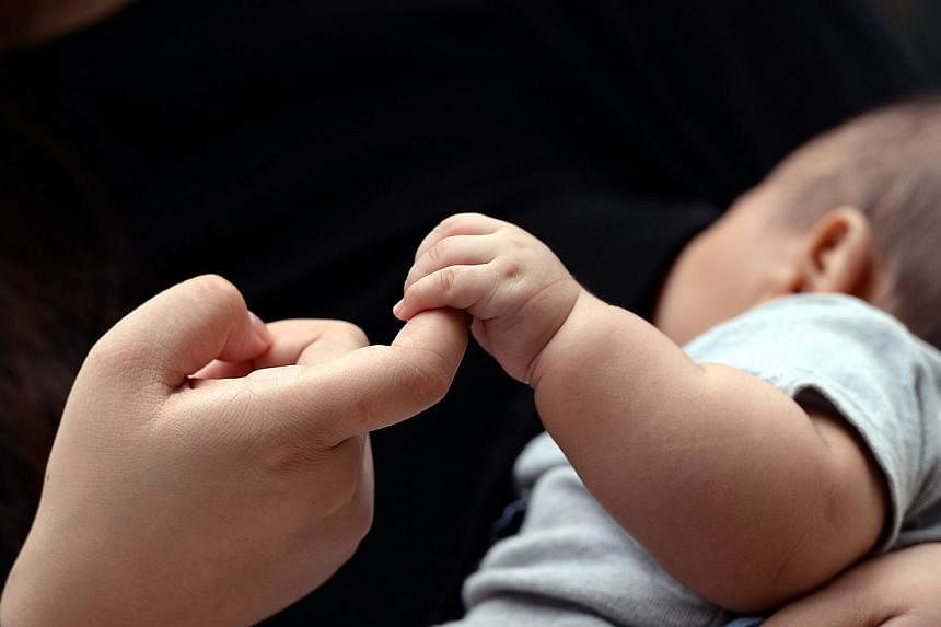 A baby grabs the finger a parent. -- PHOTO:&nbsp;CHOO CHWEE HUA