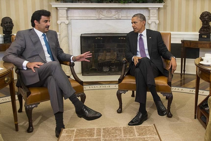 US President Barack Obama (right) and Qatar's emir, Sheikh Tamim Hamad al-Thani, speaking during a bilateral meeting at the White House on Feb 24, 2015. -- PHOTO: AFP