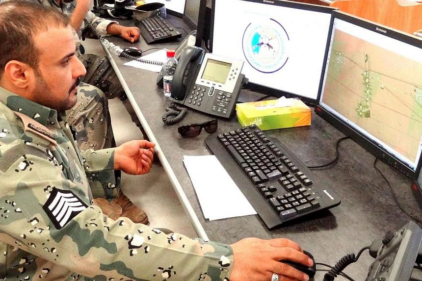 Saudi border guards monitor cameras and radars on surveillance screens of the Saudi northern border with Iraq at Arar regional command and control centre headquarters in Arar city. Inaugurated last September, the double-fence system and its complemen