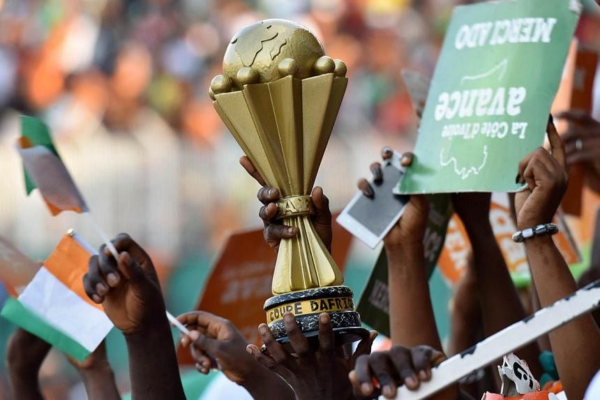 Ivorians hold a replica of the African Cup of Nations trophy as they attend a welcoming ceremony at Felix Houphouet Boigny Stadium to greet their national football team in Abidjan on Feb 9, 2015, a day after Ivory Coast won the 2015 African Cup of Na