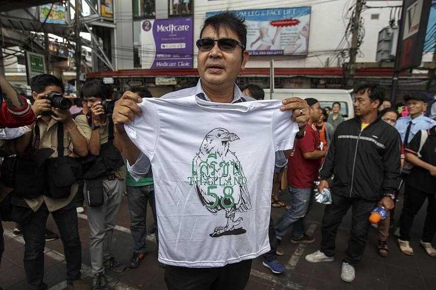 Thai pro-democracy protester Akkarakit Noonchan (centre) holds up his symbolic T-shirt near Victory Monument in Bangkok on&nbsp;Feb 22, 2015. Thailand's Parliament voted overwhelmingly on Thursday,&nbsp;Feb 26, 2015,&nbsp;in favour of a Bill that res
