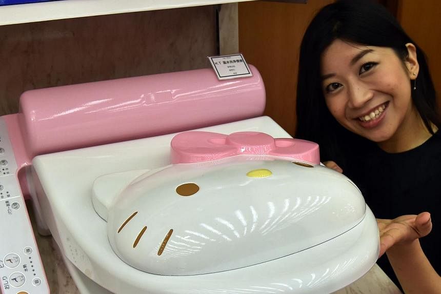 An employee for Japanese character goods maker Sanrio displays a prototype model of a Hello Kitty branded toilet seat at Sanrio's headquarters in Tokyo on Feb 2, 2015. The built-in bottom washers and pre-warmed seats of Japan's luxury toilets have be