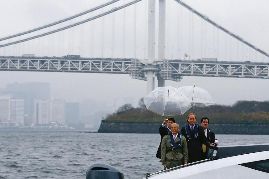 Tokyo Governor Yoichi Masuzoe (front left) poses with Britain's Prince William (front right) on a boat in front of the skyline of Tokyo on&nbsp;Feb 26, 2015, during his first trip to Japan. -- PHOTO: REUTERS