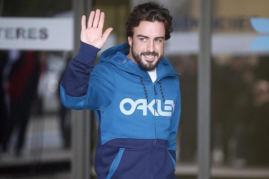 McLaren's Formula One driver Fernando Alonso of Spain gestures to the media as he leaves a hospital where he has been hospitalised since Sunday, in Sant Cugat, north of Barcelona Feb 25, 2015. -- PHOTO: REUTERS