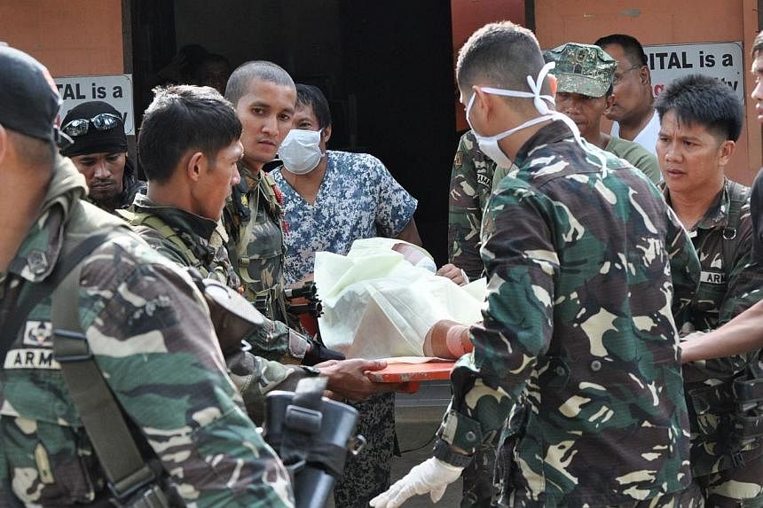 Philippine soldiers evacuating a wounded comrade, after clashes with Abu Sayyaf fighters on the southern island of Mindanao on Feb 25, 2015, to a nearby military hospital in Zamboanga City. -- PHOTO: AFP