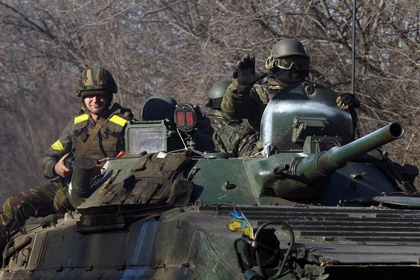 Ukrainian servicemen on an armoured personal carrier on Feb 22, 2015, near Artemivsk, in the Donetsk region, eastern Ukraine. -- PHOTO: AFP